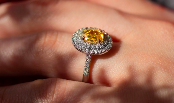 Yellow diamond engagement ring worn on ring finger